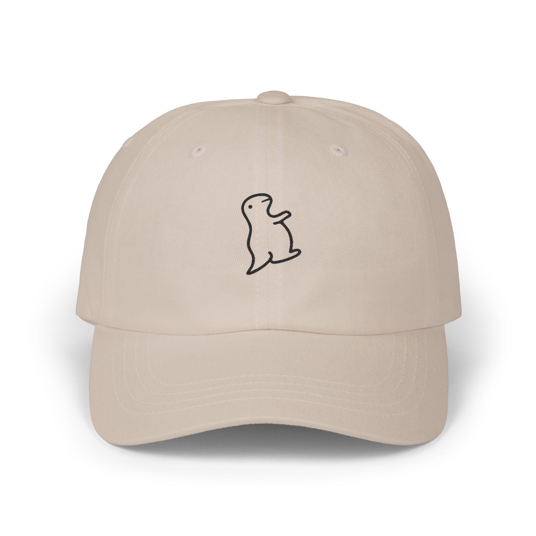 TUCURUCU beige unstructured cotton 6-panel cap with a small embroidered wistful character on the front.