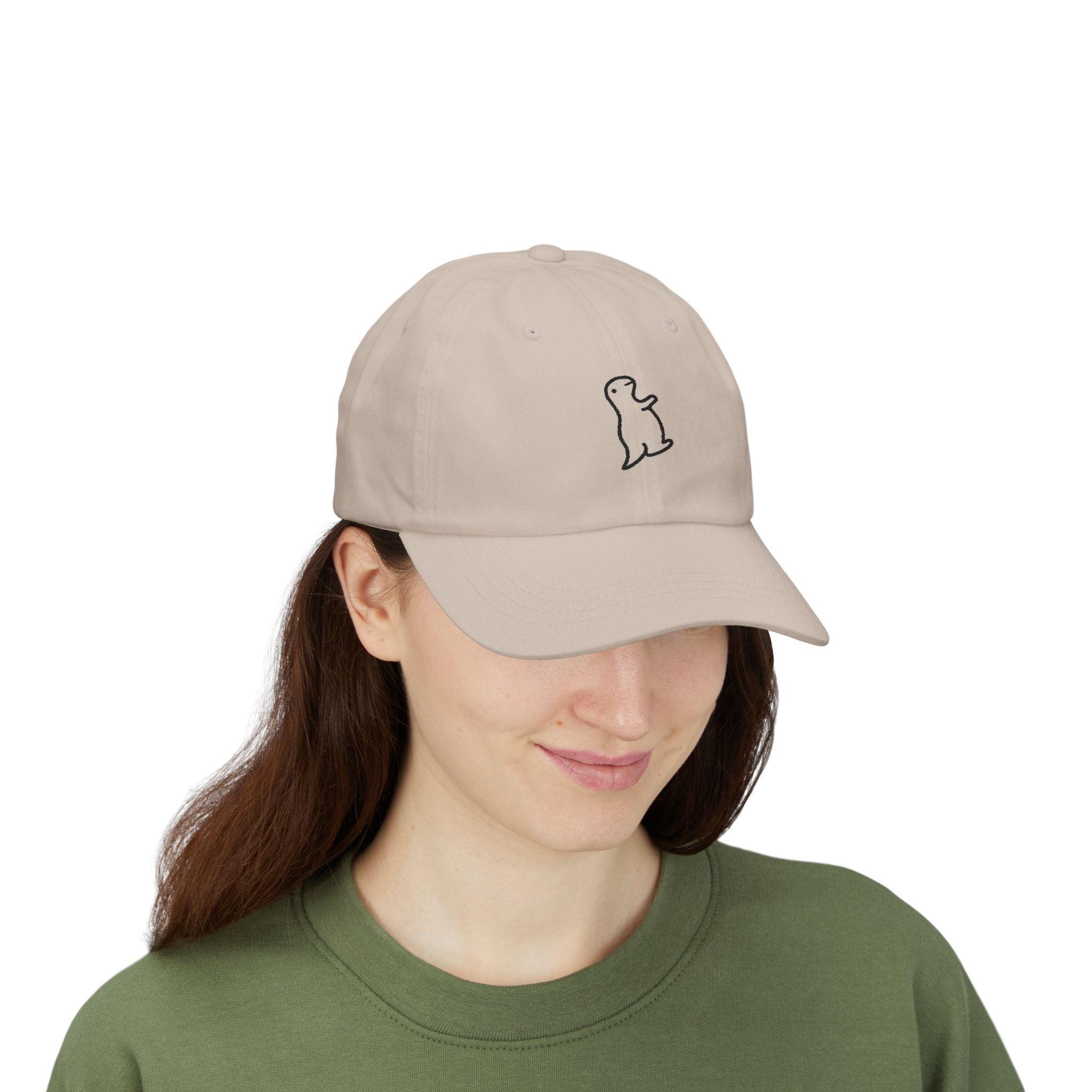 TUCURUCU beige cotton 6-panel cap with a small embroidered character on the front, worn by a woman.