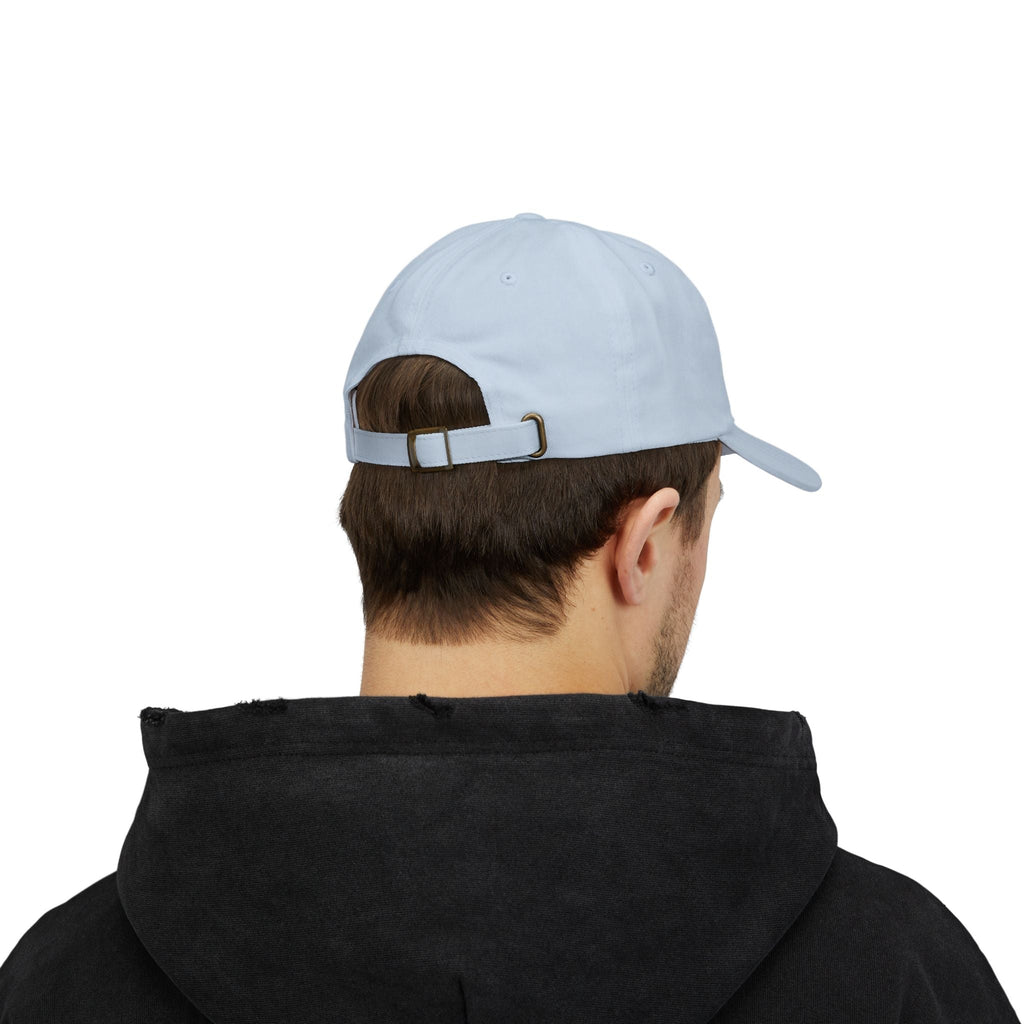 TUCURUCU Daily Walk cap in light blue cotton with an adjustable antique-brass buckle strap, worn by a man.